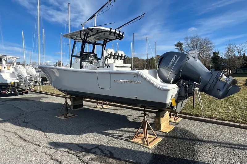 Slide: The Image of 2019 Sportsman Open 282 Center Console boat in a marina, surrounded by other vessels. - 8