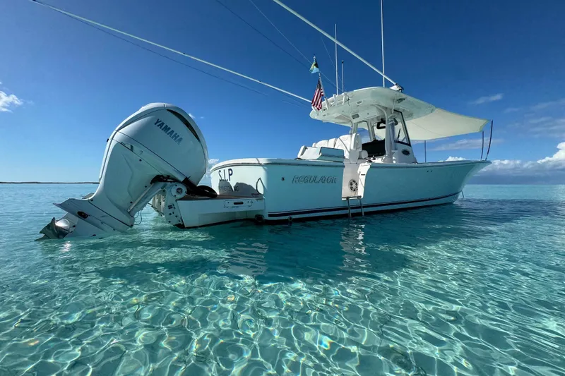Slide: The Image of 2024 Regulator 34 Center Console boat on clear turquoise water under blue sky. - 2