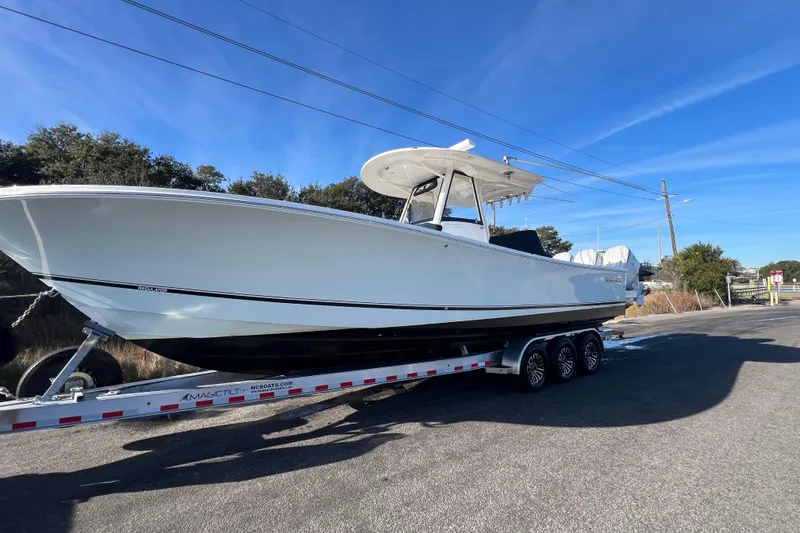 Slide: The Image of 2024 Regulator 34 Center Console boat on clear turquoise water, featuring Yamaha engines. - 3