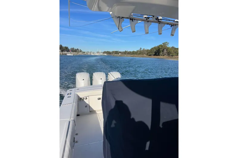 Slide: The Image of 2024 Regulator 34 Center Console boat on calm water, showcasing spacious deck design. - 8