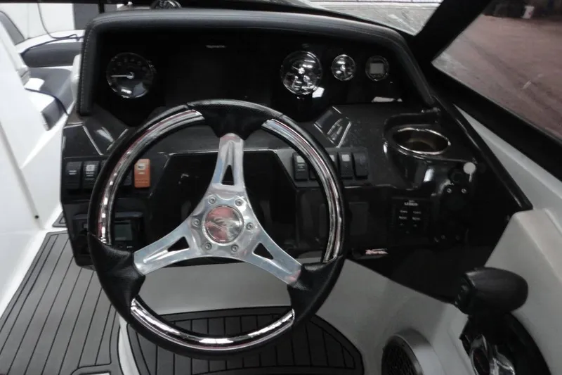 Slide: The Image of 2021 Monterey M-65 boat interior with sleek seating and modern dashboard in a showroom. - 13