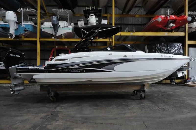 Slide: The Image of 2021 Monterey M-65 boat in storage facility with multiple boats stacked above. - 2