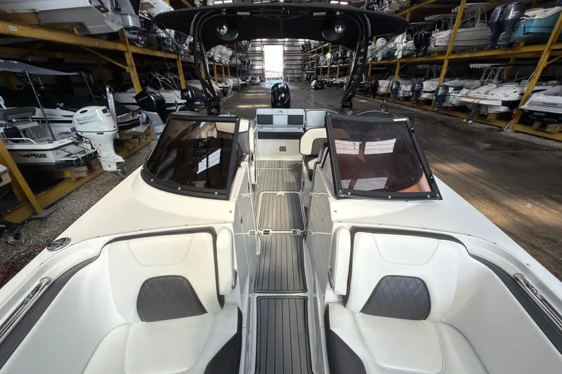 Slide: The Image of 2021 Monterey M-65 boat interior with white seating and sleek design in a storage facility. - 30