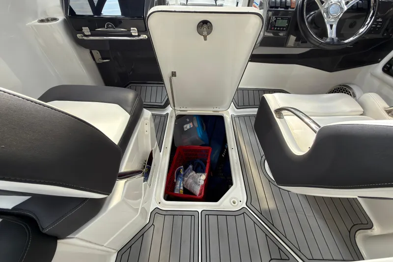 Slide: The Image of Interior of 2021 Monterey M-65 boat with open storage compartment between seats. - 31