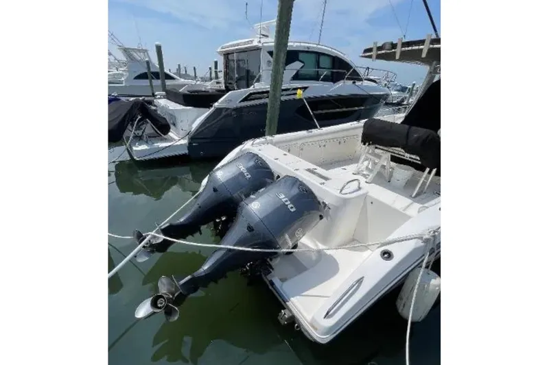 Slide: The Image of 2004 Century 3200 Center Console boat with twin outboard engines docked at marina. - 12