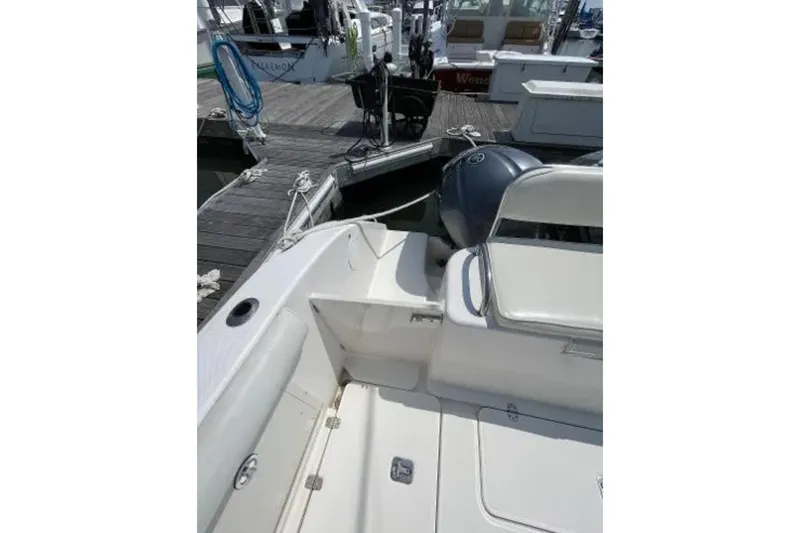 Slide: The Image of 2004 Century 3200 Center Console boat docked, featuring seating and engine view. - 22