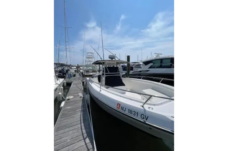 Slide: The Image of 2004 Century 3200 Center Console boat docked at marina under clear blue sky. - 3