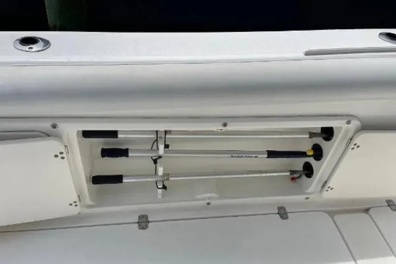 Slide: The Image of Storage compartment on a 2004 Century 3200 Center Console boat, holding fishing rods. - 49