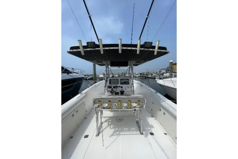 Slide: The Image of 2004 Century 3200 Center Console boat with fishing rods, docked in a marina. - 53