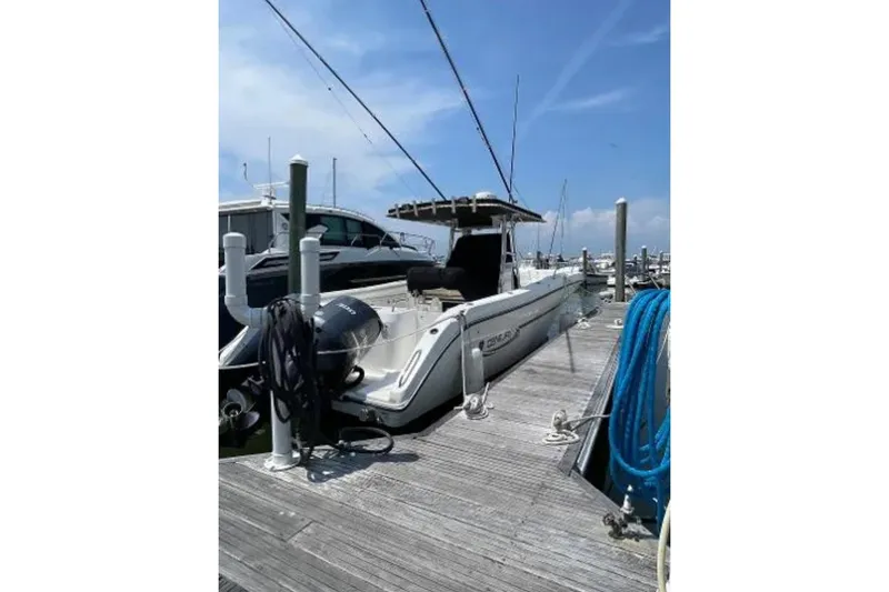 Slide: The Image of 2004 Century 3200 Center Console boat docked at marina under clear blue sky. - 8
