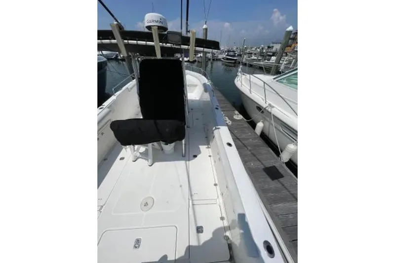 Slide: The Image of 2004 Century 3200 Center Console boat docked at marina, featuring spacious deck. - 9