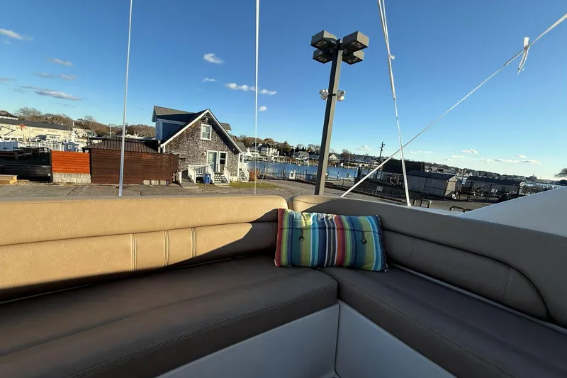 Slide: The Image of 2002 Regal Commodore 3860 yacht with striped pillow, docked near waterfront house. - 16