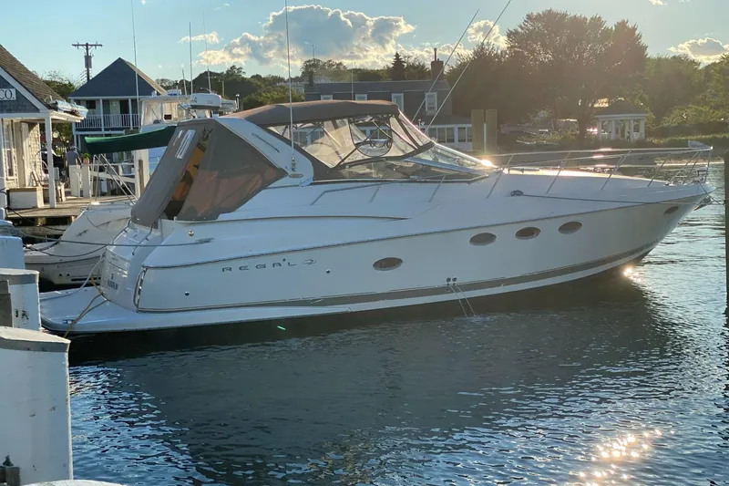 Slide: The Image of 2002 Regal Commodore 3860 yacht docked at marina, reflecting sunlight on water. - 21