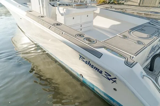 Slide: The Image of 2015 Bahama 34 boat docked, showcasing sleek design and spacious deck. - 11