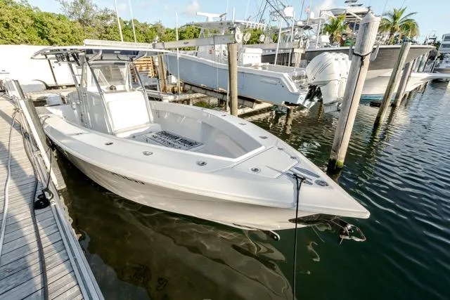 Slide: The Image of 2015 Bahama 34 boat docked at marina, featuring sleek design and spacious deck. - 16