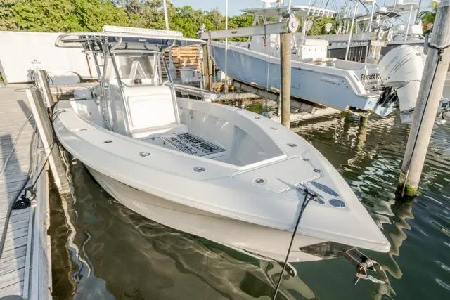 Slide: The Image of 2015 Bahama 34 boat docked in marina, featuring sleek design and spacious deck. - 17