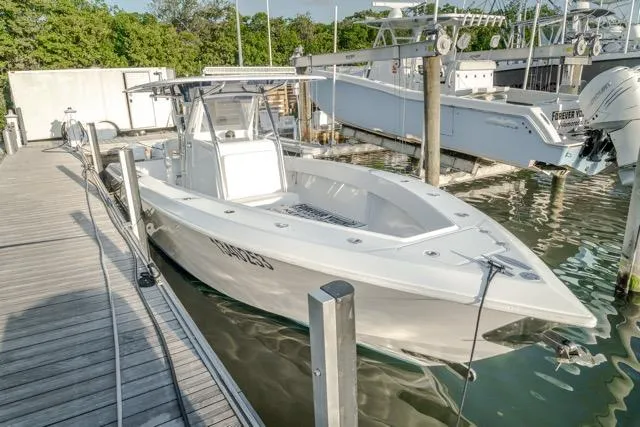 Slide: The Image of 2015 Bahama 34 boat docked at marina, featuring sleek design and spacious deck. - 19
