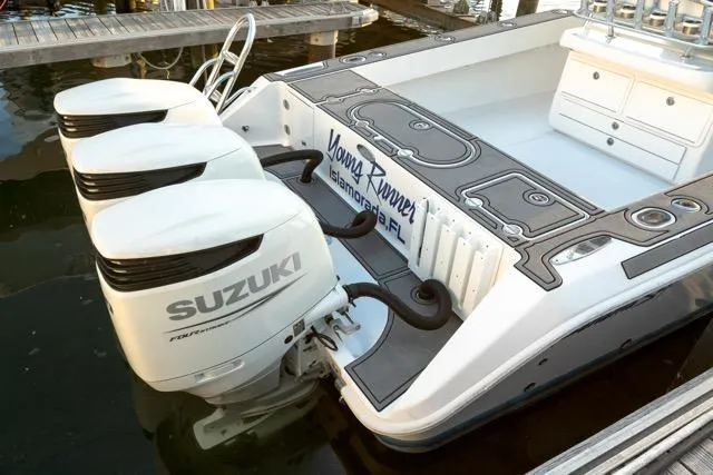 Slide: The Image of 2015 Bahama 34 boat with triple Suzuki outboard motors docked at marina. - 22