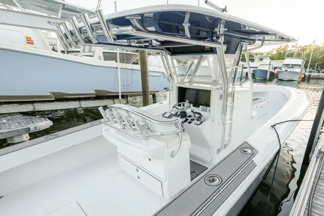 Slide: The Image of 2015 Bahama 34 boat docked, featuring sleek design and modern console. - 23