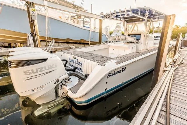 Slide: The Image of 2015 Bahama 34 boat with Suzuki engine docked at marina. - 24