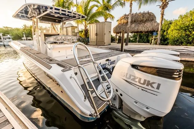 Slide: The Image of 2015 Bahama 34 boat docked with Suzuki engines, surrounded by tropical scenery. - 25