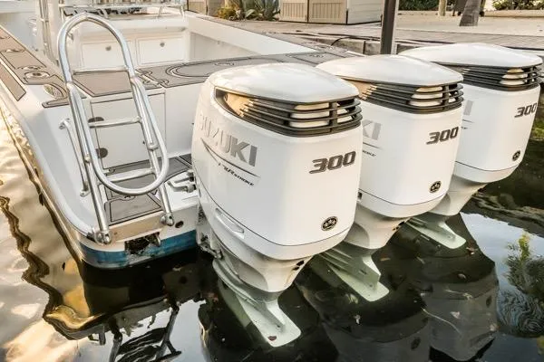 Slide: The Image of 2015 Bahama 34 boat with triple Suzuki 300 outboard engines, docked in calm water. - 26