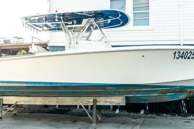 Slide: The Image of 2015 Bahama 34 boat on dry dock near a white building. - 31