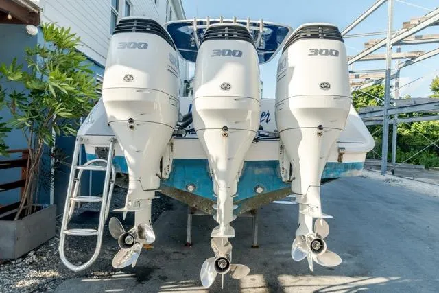 Slide: The Image of Triple outboard engines on a 2015 Bahama 34 boat, parked outdoors. - 33