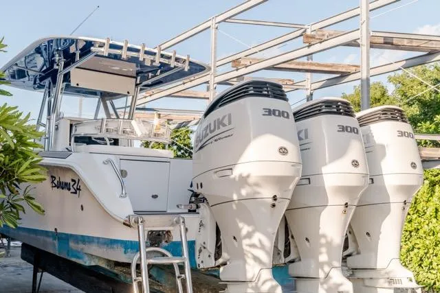 Slide: The Image of 2015 Bahama 34 boat with triple Suzuki 300 engines, docked outdoors. - 34