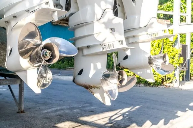 Slide: The Image of Outboard motors of a 2015 Bahama 34 boat, featuring shiny propellers. - 35
