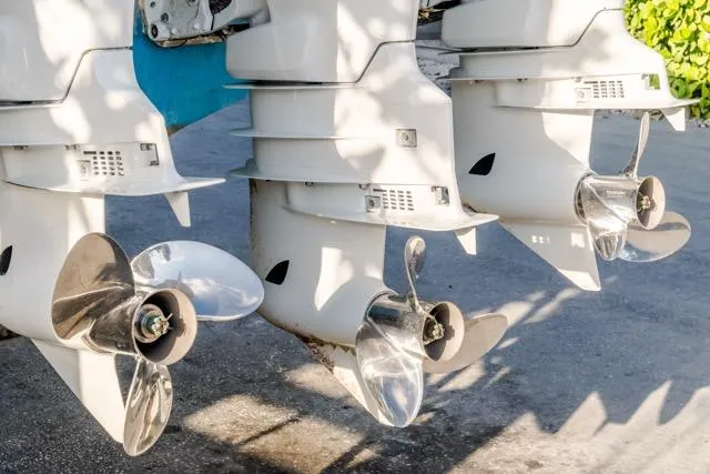 Slide: The Image of Three outboard motors on a 2015 Bahama 34 boat, showcasing shiny propellers. - 36