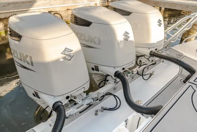 Slide: The Image of Triple Suzuki outboard engines on a 2015 Bahama 34 boat, docked in water. - 40