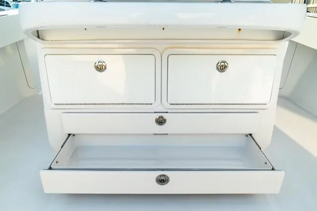 Slide: The Image of 2015 Bahama 34 boat storage compartments with open drawer, showcasing ample space. - 46