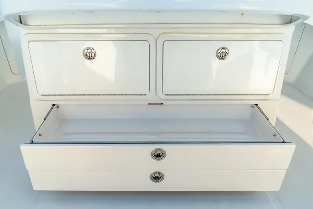 Slide: The Image of White storage drawers on a 2015 Bahama 34 boat, featuring sleek chrome handles. - 47