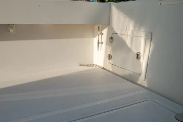 Slide: The Image of Interior view of a 2015 Bahama 34 boat, showcasing a clean, white storage compartment. - 49
