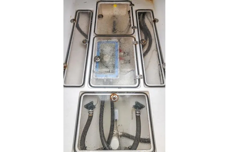 Slide: The Image of Engine compartment of a 2015 Bahama 34 boat with visible hoses and components. - 53