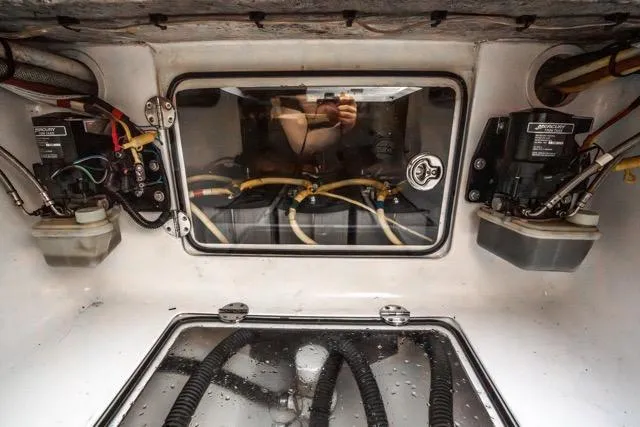 Slide: The Image of Interior view of a 2015 Bahama 34 boat's engine compartment with wiring and components. - 55