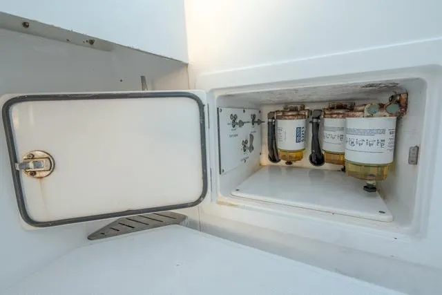 Slide: The Image of Fuel filter compartment of a 2015 Bahama 34 boat, showcasing maintenance access. - 60