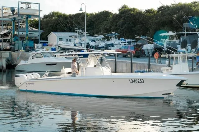 Slide: The Image of 2015 Bahama 34 boat docked at marina with other vessels in background. - 8
