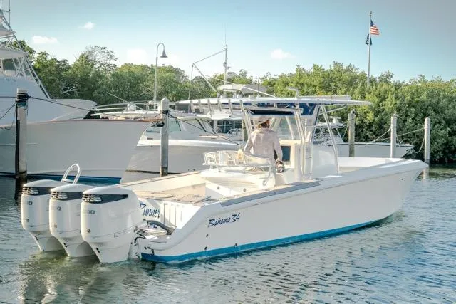 Slide: The Image of 2015 Bahama 34 boat with triple engines docked in a marina. - 9