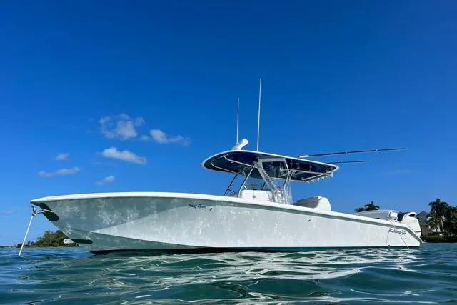 Slide: The Image of A 2015 Bahama 34 boat docked in a marina with surrounding greenery. - 2