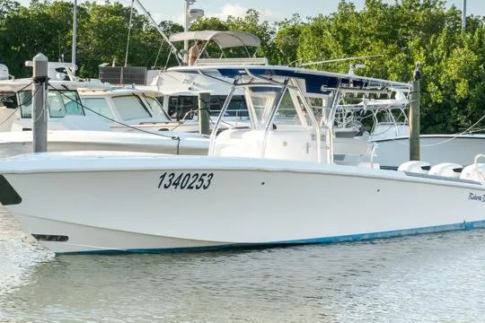 Slide: The Image of 2015 Bahama 34 boat on water, surrounded by lush greenery and palm trees. - 4