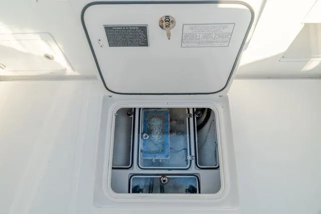 Slide: The Image of 2015 Bahama 34 boat compartment with open hatch, showcasing interior details. - 48