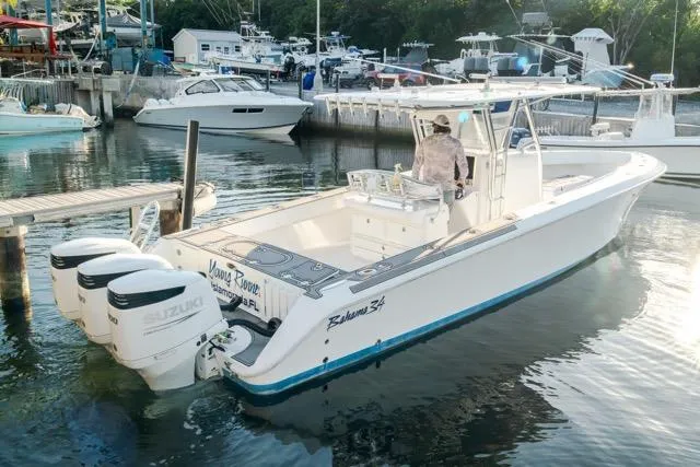 Slide: The Image of A 2015 Bahama 34 boat docked in a marina with surrounding greenery. - 5