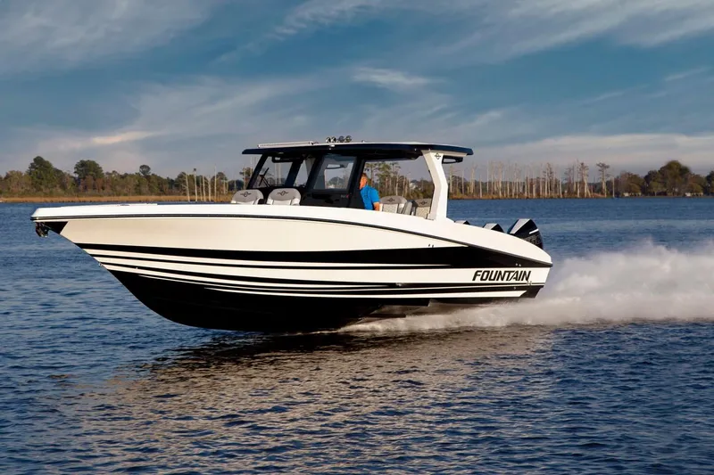 The Image of Manufacturer Provided Image: 2025 Fountain 39 SCX boat cruising on a calm lake under a clear sky. - 0