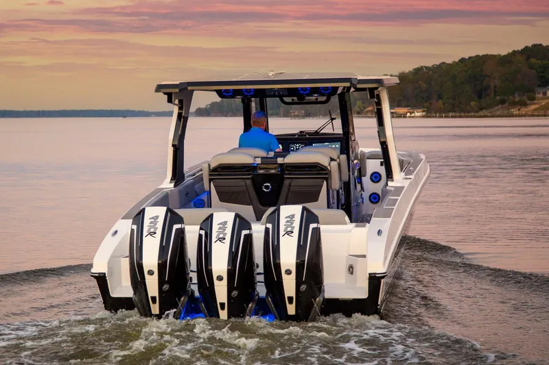 Slide: The Image of Manufacturer Provided Image: 2025 Fountain 39 SCX boat with multiple engines cruising on a serene lake at sunset. - 3