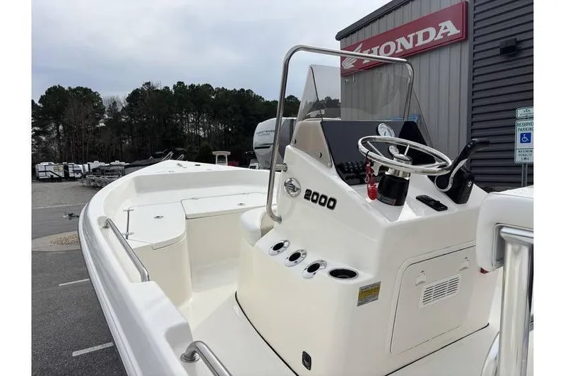Slide: The Image of 2026 Bulls Bay 2000 boat with steering console, parked near Honda dealership. - 12