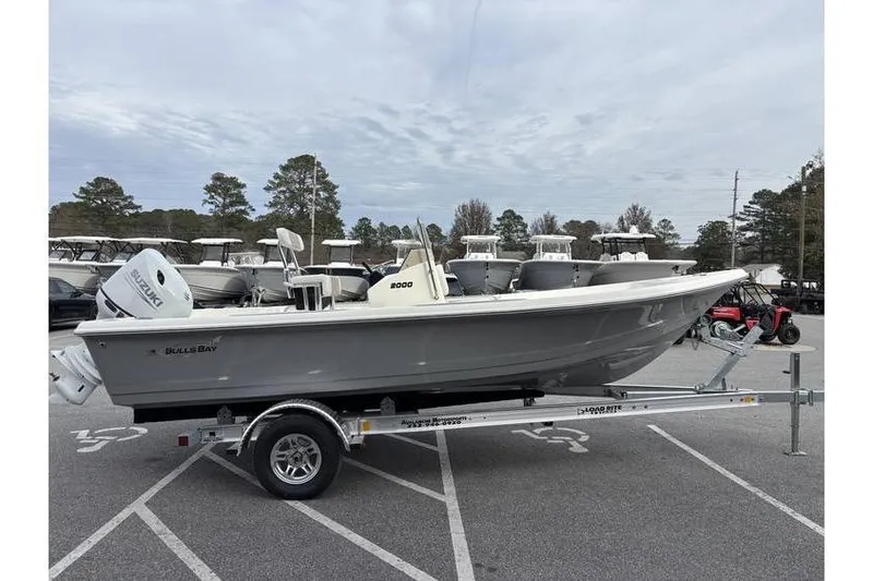 Slide: The Image of 2026 Bulls Bay 2000 boat on trailer in parking lot, overcast sky. - 6
