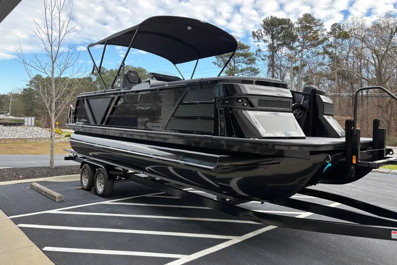 Slide: The Image of 2026 Veranda Vertex 235RC Premium pontoon boat on trailer, parked outdoors. - 3