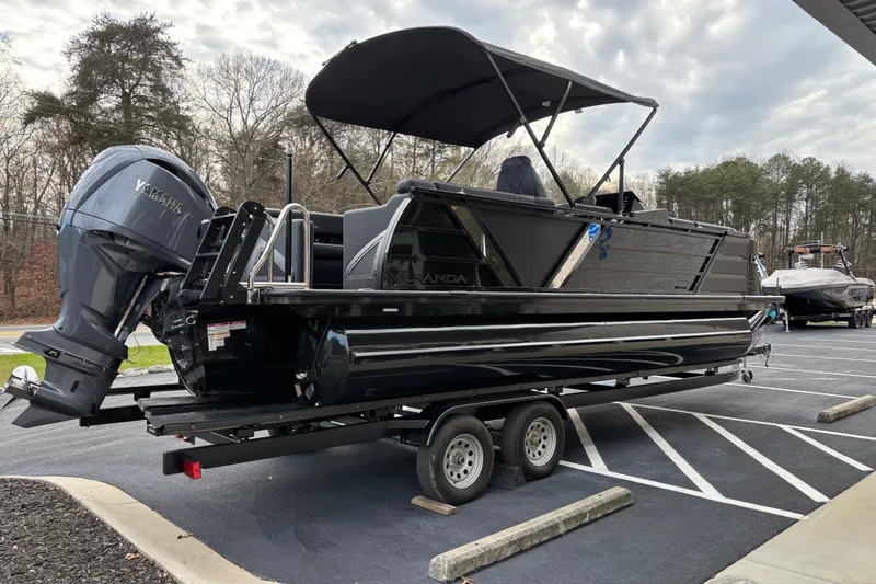 Slide: The Image of 2026 Veranda Vertex 235RC Premium pontoon boat on trailer, parked outdoors. - 4